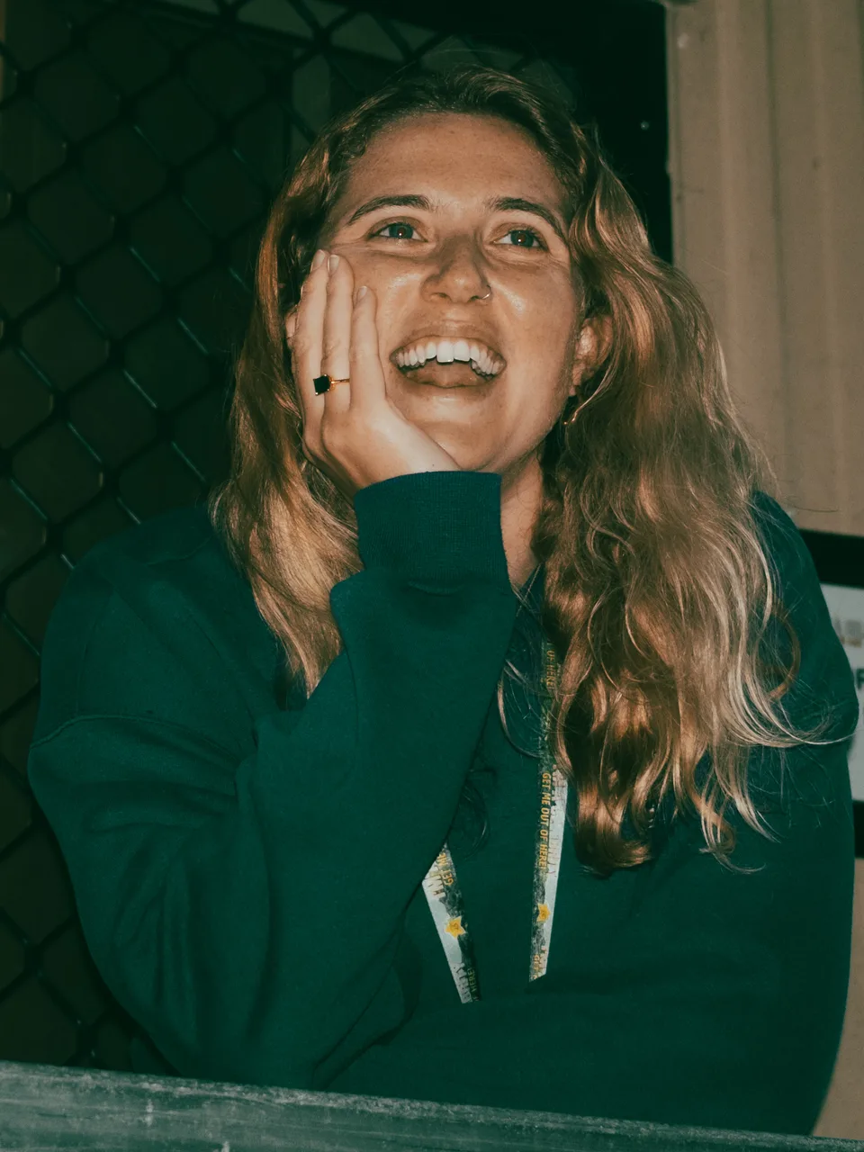 Megs laughing candidly, hand to her face, at a race event check-in booth.